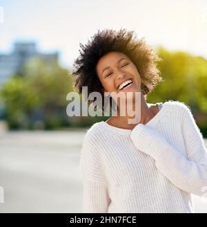 Wie schön ist es, sie glücklich zu sehen. Aufnahme einer glücklichen jungen Frau, die in die Stadt geht. Stockfoto