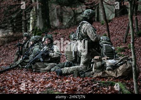 Litauische Soldaten der Nationalen Freiwilligenschutztruppe (KASP) ziehen während der kombinierten Auflösung XVI mit Mitgliedern der 10th U.S. Army Special Forces Group in Hohenfels, Deutschland, am 7. Dezember 2021 an Sicherheit. Combined Resolve XVI ist ein 7th Army Training Command Event, das die Fähigkeit zur Durchführung komplexer Operationen bewertet und gleichzeitig die Interoperabilität mit konventionellen Kräften verbessert. (USA Armeefoto von Sgt. Stanford Toran) Stockfoto