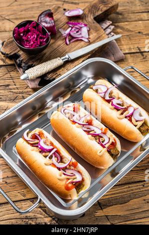 Vegan Vegetarische Hotdogs mit Zwiebeln und fleischloser Wurst. Holzhintergrund. Draufsicht Stockfoto