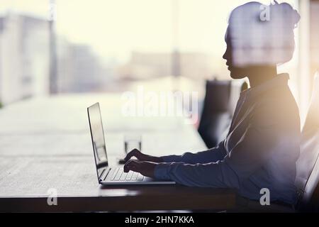 Große Träume erfordern harte Arbeit. Eine kurze Aufnahme einer Geschäftsfrau, die im Büro an ihrem Laptop arbeitet. Stockfoto