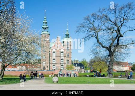 KOPENHAGEN, DÄNEMARK - 30. APRIL 2017: Das Schloss Rosenborg ist ein Renaissanceschloss neben dem Königlichen Garten, erbaut von König Christian IV. Blühende Bäume im Vordergrund. Frontalansicht. Stockfoto