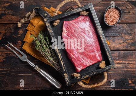 Grass Fed Roh Flanke Rindfleisch Fleischsteak in Holzschale mit Kräutern. Holzhintergrund. Draufsicht Stockfoto