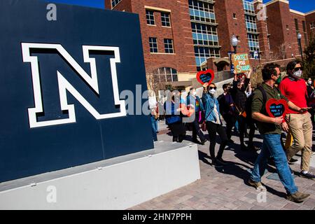 Reno, Usa. 14th. Februar 2022. Studenten marschieren während der Demonstration an einem Campus-Schild vorbei.Studenten versammelten sich am Valentinstag zu einem Protest, um ihre Universität zu bitten, das Maskenmandat wieder einzusetzen, nachdem es am 10th. Februar vom Gouverneur von Nevada, Steve Sisolak, entfernt wurde. Kredit: SOPA Images Limited/Alamy Live Nachrichten Stockfoto