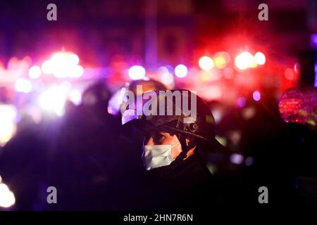 Manila, Philippinen. 14th. Februar 2022. Ein Feuerwehrmann arbeitet entlang einer Straße, während er ein Feuer kontrolliert, das am Montagabend ein Wohngebiet in Quezon City, Philippinen, erfasst hat. 14. Februar 2022. Die Behörden versuchen immer noch, die Ursache des Feuers zu ermitteln, der mehrere Häuser zerstört hat. (Bild: © Basilio Sepe/ZUMA Press Wire) Stockfoto