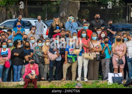 Caracas, Miranda, Venezuela. 14th. Februar 2022. Nachbarn und Passanten beobachten die kollektive Hochzeit auf dem Platz.Kollektivhochzeit auf der Plaza Francia in Altamira am Valentinstag. Caracas, Venezuela (Kreditbild: © Jimmy Villalta/ZUMA Press Wire) Stockfoto