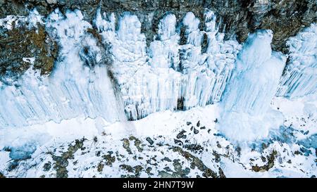 Im Grunde genommen ein gefrorener Wasserfall, wenn der Schnee schmilzt und an der Felswand wieder gefriert. Stockfoto