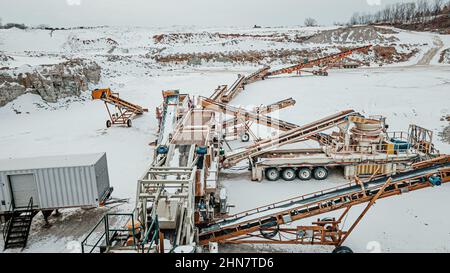 Auch im Winter wird im Steinbruch Stein zu Kies geschliffen Stockfoto