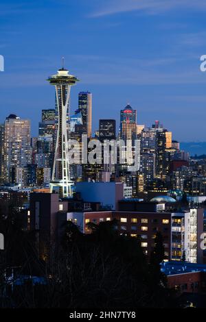 Seattle - 11. Februar 2022; die Skyline von Seattle leuchtet in der Abenddämmerung hinter der Space Needle unter blauem Himmel Stockfoto