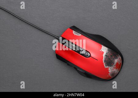 Defekte Computermaus mit Verbindungskabel auf dunkelgrauem Hintergrund Stockfoto