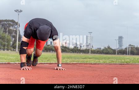 Mann, der Bergsteiger an einem sonnigen Morgen in Sportkleidung in einem Park trainiert Stockfoto
