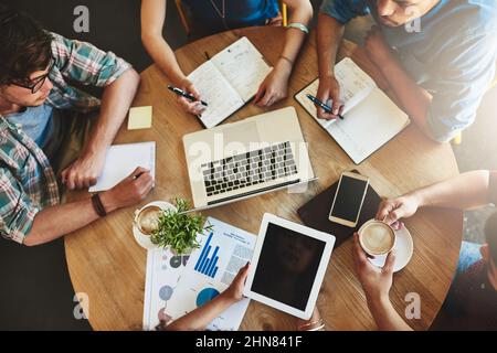 Der Austausch von Informationen hilft ihnen, ihre Prüfungen zu bestehen. Aufnahme einer Gruppe von Studenten, die in einem Café studieren. Stockfoto