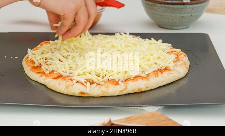 Pizzateig mit Mozzarella-Käse überbacken. Hausgemachte Mozzarella- Pilz Pizza Schritt für Schritt Rezept Stockfoto