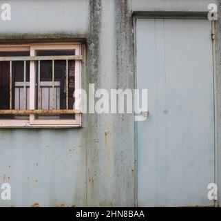 Verwittertes grünes Transportcontainer-Büro in der Nähe der Baustelle Stockfoto