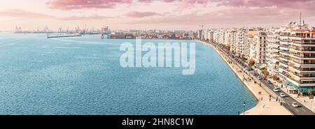 Luftpanorama über die Promenade der Stadt Thessaloniki mit Fassaden von Gebäuden und einem geschäftigen Frachtschiffhafen vom Aussichtspunkt White Tower. Besuchen Sie Griechenland A Stockfoto