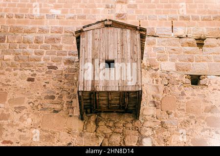 Der Eingang zum Kloster ist über einen Aufzug erreichbar. Holzstruktur auf einer Steinmauer Stockfoto