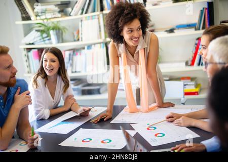 Eine Gruppe erfolgreicher, glücklicher, multiethnischer Geschäftsleute, die als Team im Büro bei der Besprechung arbeiten. Stockfoto