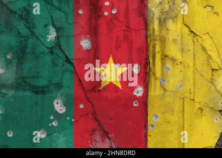 Vollformat-Foto einer verwitterten Flagge von Kamerun auf einer rissigen Wand mit Einschusslöchern gemalt. Anglophones Krisenbürgerkriegskonzept. Stockfoto