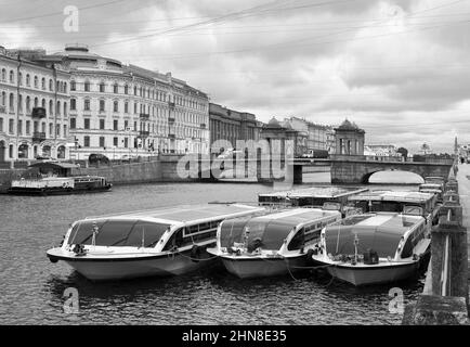 Sankt Petersburg/Russia-09/01/2020: Vergnügungsboote auf dem Hintergrund der Lomonosov-Brücke auf Fontanka. Pier am Ufer, Granit Tetrapylons Stockfoto