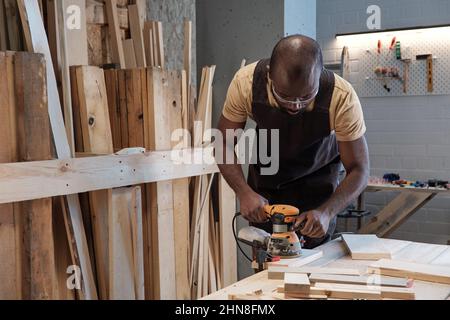 Taille up Porträt von reifen schwarzen Tischler Holz mit Elektrowerkzeug in der Werkstatt, kopieren Raum Stockfoto