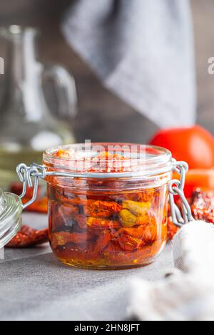 Sonnengetrocknete Tomaten. Eingelegte Tomaten im Glas auf Küchentisch. Stockfoto