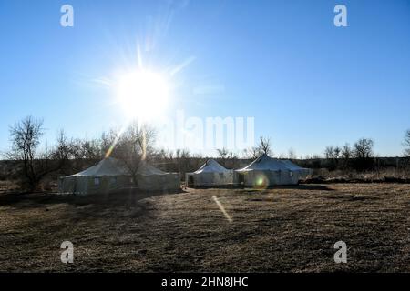 REGION ZAPORIZHZHIA, UKRAINE - 14. FEBRUAR 2022 - die Sonne scheint über den Zelten des innerhalb von 24 Stunden in Zaporizhzh erlegten Militärausbildungszentrums Stockfoto