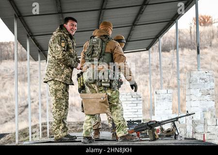 REGION SAPORISCHSCHSCHJA, UKRAINE - 14. FEBRUAR 2022 - Oleksandr Starukh (L), Leiter der regionalen Staatsverwaltung Saporischschschja, besucht einen Schießstand Stockfoto