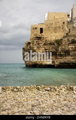 Vertikale Aufnahme der alten Gebäude am Ufer. Lama Monachile, Polignano a Mare, Italien. Stockfoto