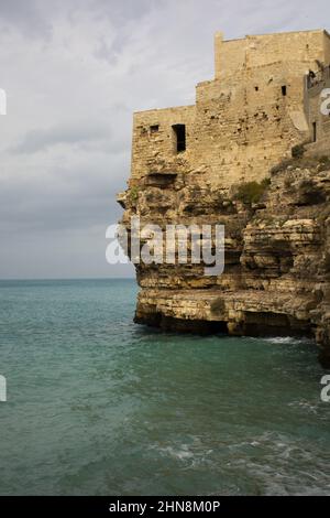 Vertikale Aufnahme der alten Gebäude am Ufer. Lama Monachile, Polignano a Mare, Italien. Stockfoto