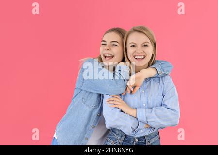 Konzept der Freundschaft mit zwei Mädchen auf rosa Hintergrund Stockfoto