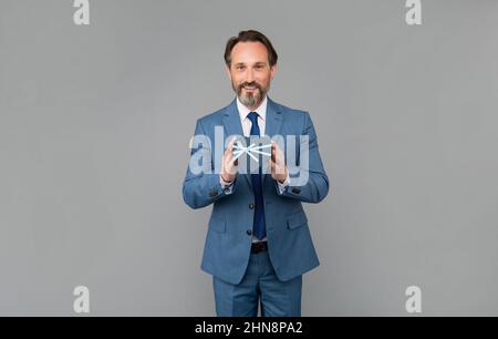 Geschenk für den Frauentag. Senior ceo halten Corporate geschenkbox. Stockfoto