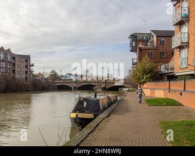 Allgemeiner Blick auf den Fluss Nene bei Southbridge Northampton UK an einem sonnigen Wintertag; festgeschraubtes Schmalboot und Frau beim Training. Stockfoto