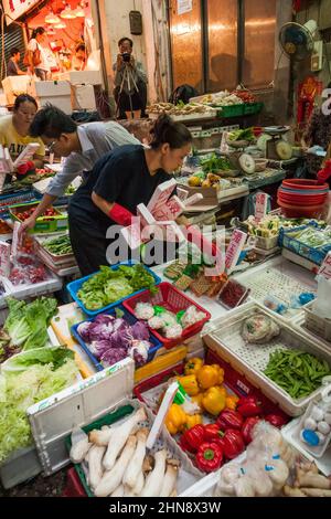 Ein Mann fotografiert den Lebensmittelmarkt in der Peel Street, Central, Hong Kong Island Stockfoto