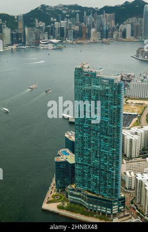 Luftaufnahme aus dem Hubschrauber des Harbourfront Landmark, einer luxuriösen Wohnanlage mit 3 Türmen in Hung Hom, Kowloon, mit der Insel Hong Kong über Victoria Harbo Stockfoto