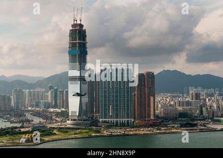 Der Hubschrauber des Macau Sky Shuttle fliegt vor dem im Bau befindlichen ICC, West Kowloon, Hongkong, 2008 Stockfoto