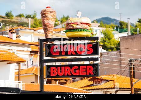 25. Oktober 2021, Neos Marmaras, Griechenland: Außenwerbung und ein Schild vor dem Eingang zu einem Street-Food-Restaurant mit Gyros Stockfoto