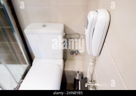 Notruftelefon an der Wand in der Hoteltoilette. Erste Hilfe und Unfall Stockfoto