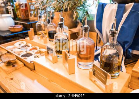 Flaschen mit verschiedenen Sorten von Olivenölen aus Griechenland am Buffet Stockfoto