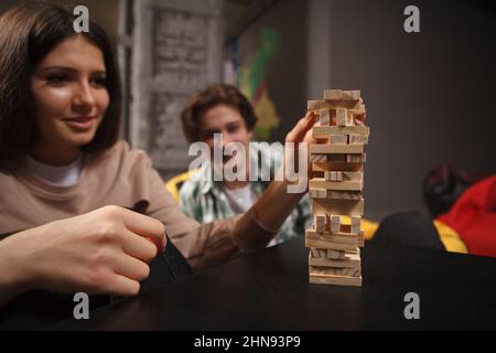 Selektiver Fokus auf gestapelte Holzklumpen, junges Paar genießt Brettspiele zusammen zu spielen Stockfoto