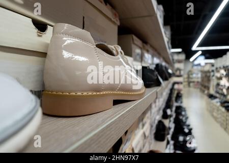 Schuhe aus Lackleder im Laden. Schuhe sind in einer Reihe. Viele Schuhe. Selektiver Fokus Stockfoto