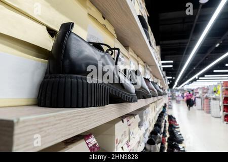 Schwarze Schuhe im Laden. Schuhe sind in einer Reihe. Viele Schuhe. Selektiver Fokus Stockfoto
