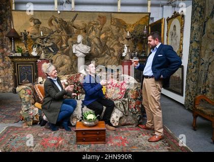 Billingshurst , Sussex, UK 15th February 2022 - von links Sara Cooper , Adam Garner und will Pasfield von Bellmans Fine Art Auctioneers, Wisborough Green bei Billingshurst mit Onkel Monty's berühmtem Sofa, das nächste Woche unter den Möbeln versteigert wird. Gegenstände aus dem Haus von Professor Bernard Nevill, dessen Wohnung in Chelsea der Ort für die Wohnung von Onkel Monty im Film „Withnail & I“ war, der in diesem Jahr sein 35th-jähriges Jubiläum feiert, werden nächste Woche am 23rd. Februar versteigert: Credit Simon Dack / Alamy Live News Stockfoto