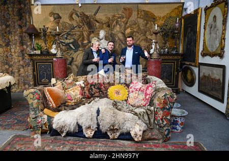 Billingshurst , Sussex, UK 15th February 2022 - von links Sara Cooper , Adam Garner und will Pasfield von Bellmans Fine Art Auctioneers, Wisborough Green bei Billingshurst mit Onkel Monty's berühmtem Sofa, das nächste Woche unter den Möbeln versteigert wird. Gegenstände aus dem Haus von Professor Bernard Nevill, dessen Wohnung in Chelsea der Ort für die Wohnung von Onkel Monty im Film „Withnail & I“ war, der in diesem Jahr sein 35th-jähriges Jubiläum feiert, werden nächste Woche am 23rd. Februar versteigert: Credit Simon Dack / Alamy Live News Stockfoto