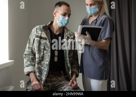 Arzt mit Militäroffizier Patient im Krankenhaus Stockfoto