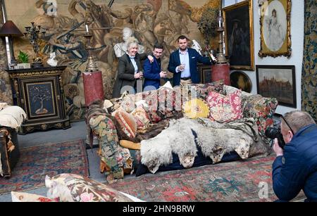 Billingshurst , Sussex, UK 15th February 2022 - von links Sara Cooper , Adam Garner und will Pasfield von Bellmans Fine Art Auctioneers, Wisborough Green bei Billingshurst mit Onkel Monty's berühmtem Sofa, das nächste Woche unter den Möbeln versteigert wird. Gegenstände aus dem Haus von Professor Bernard Nevill, Dessen Haus in Chelsea der Ort für die Wohnung von Onkel Monty im Film „Withnail & I“ war, der in diesem Jahr sein 35th-jähriges Bestehen feiert, wird nächste Woche am 23rd. Februar versteigert und Mitglieder der Öffentlichkeit sind eingeladen, Bellmans zu besuchen und die auszuprobieren Sofa für sich Stockfoto