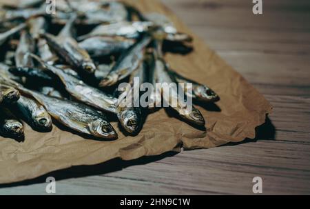 Viele sonnengetrocknete Fische auf dem Papier. Stockfoto