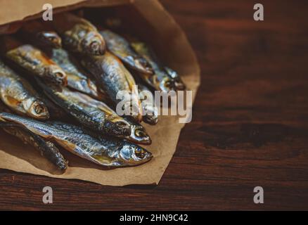 Viele sonnengetrocknete Fische in der Papiertüte. Stockfoto