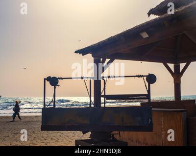 Silhouette eines Holzdachs mit Grill vor dem Meer Stockfoto