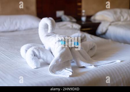 Skorpion-Figur aus Handtüchern auf einem Bett in einem Hotelzimmer. Stockfoto