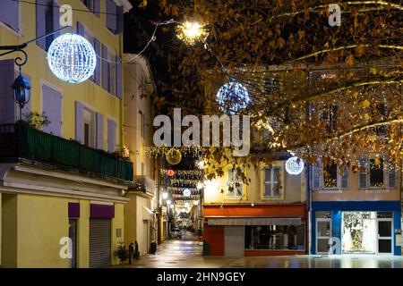 Zentrale Straße der französischen Stadt Monzelimar mit Weihnachtsschmuck in der Dämmerung Stockfoto