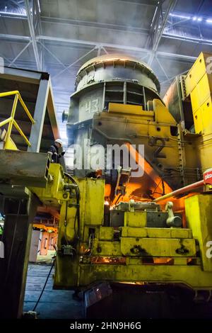 Temirtau, Kasachstan - 08. Juni 2012: Metallurgie-Anlage von Arcelor Mittal. Stahlherstellung. Schmelzofen mit elektrischem Lichtbogenofen. Zwei Arbeiter höher. Stockfoto